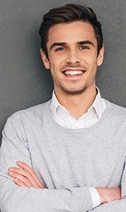 man in grey sweater smiling