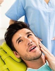 man holding cheek in pain