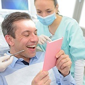 Older man looking at smile in mirror