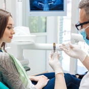 Dentist showing woman an implant model