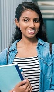 woman holding books smiling
