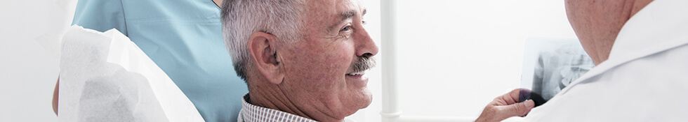 elderly man smiling at dentist