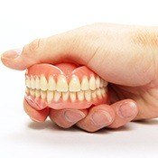 hand holding dentures