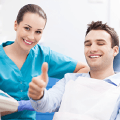 Smiling man in dental chair giving thumbs up